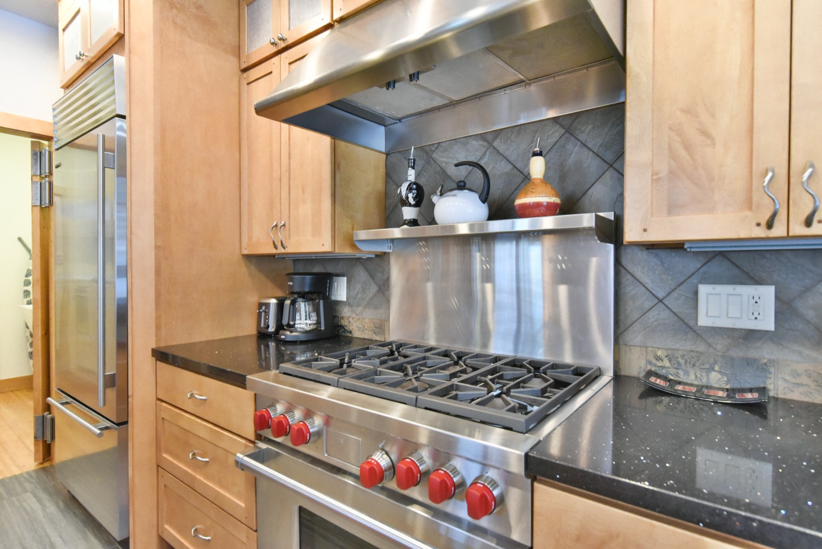 Mountain home kitchen with professional stainless range, maple cabinets, and granite counters