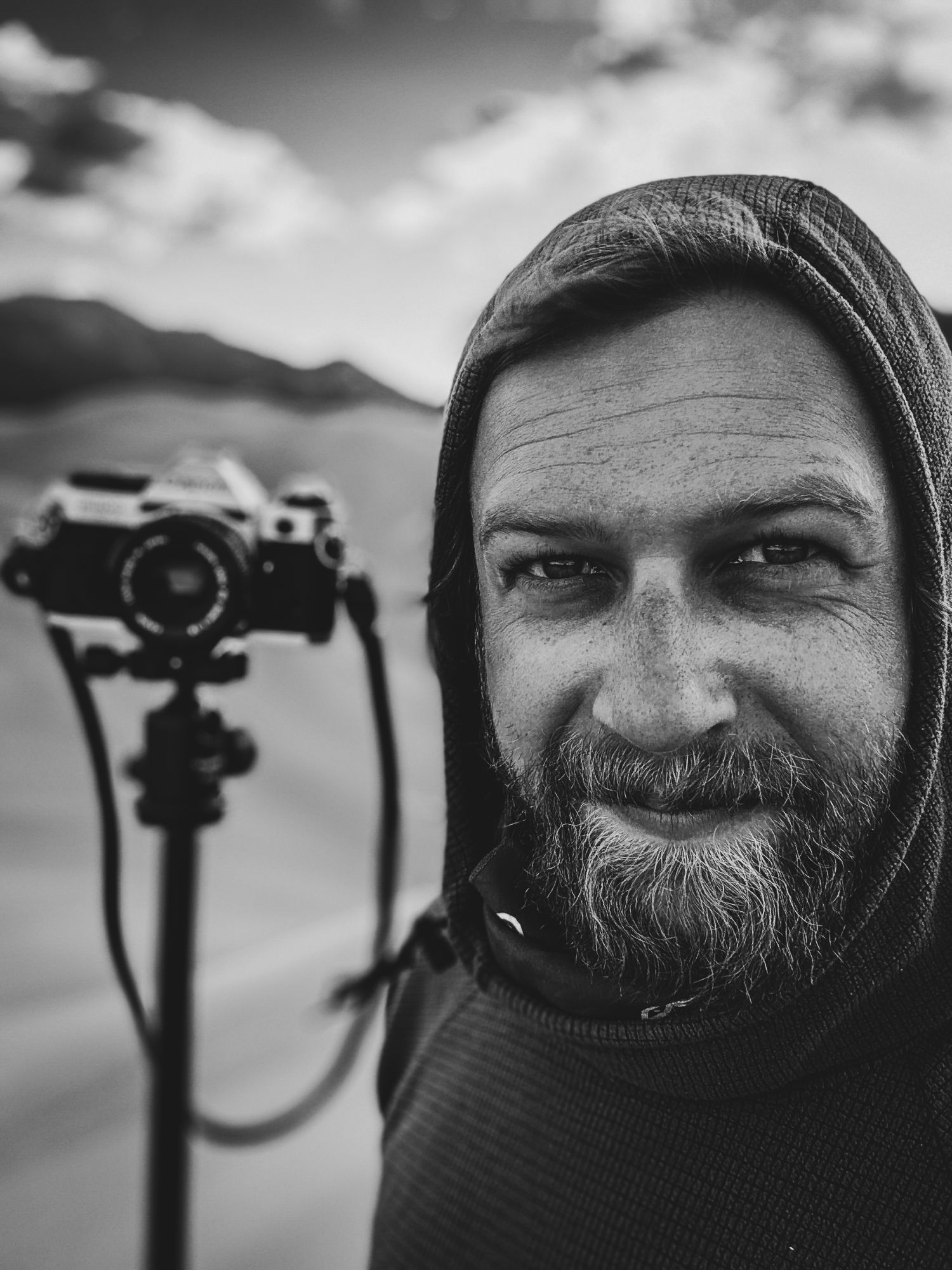Matt, owner and photographer of Cloud City Photography, with a film camera on a tripod in the mountains